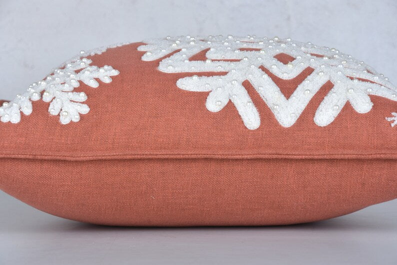 Terracotta pillow with snowflake design and pearl-like bead embellishment