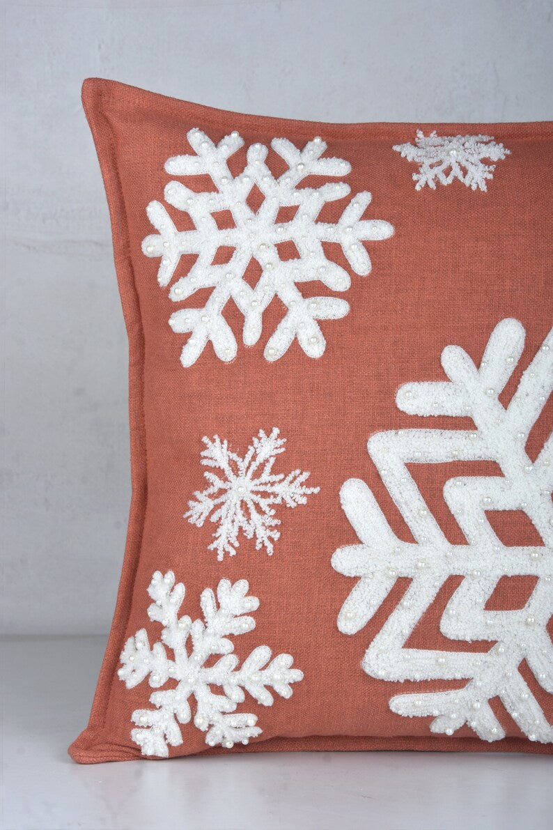 Terracotta pillow with snowflake embroidery and pearl-like beads